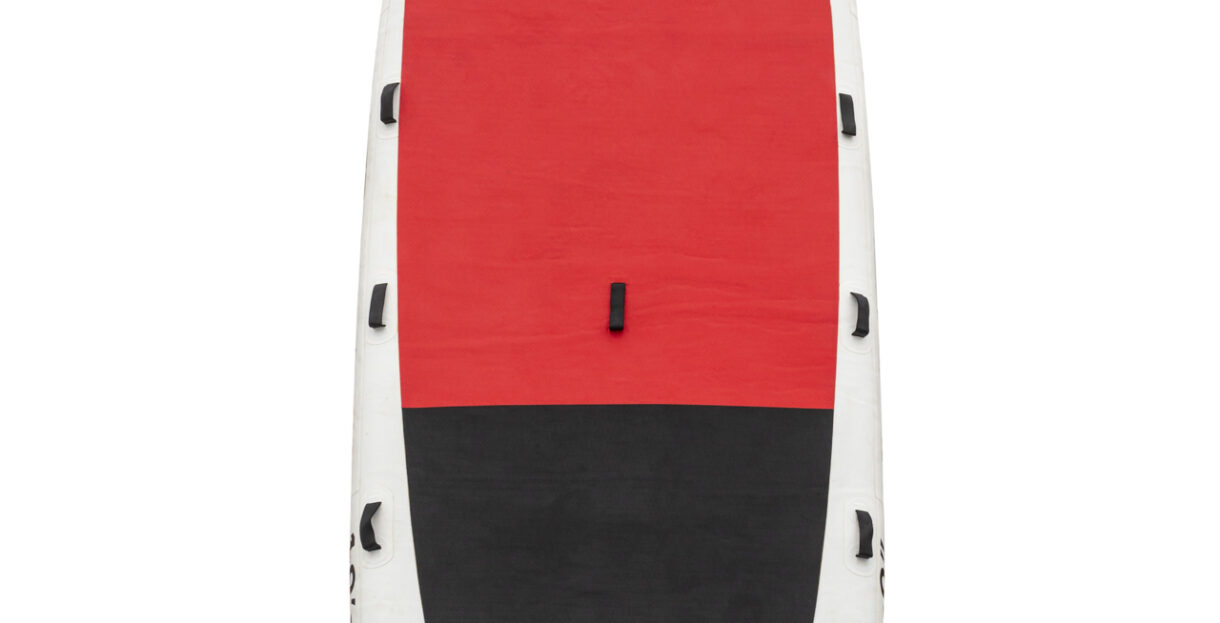 A family having fun and balancing on a large stand-up paddleboard in coastal waters