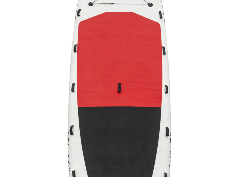 A family having fun and balancing on a large stand-up paddleboard in coastal waters